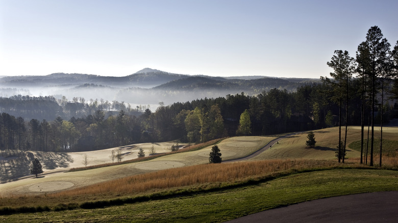 Rolling hills with trails, trees, and the Blue Ridge Mountains