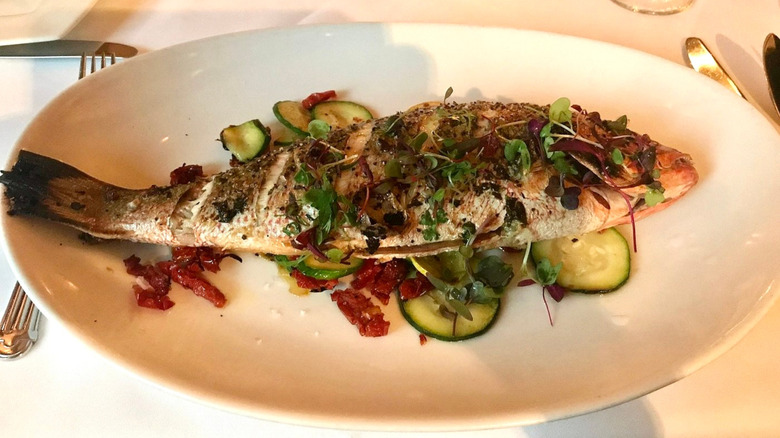 A whole fish is decorated with greens and herbs at High Cotton restaurant in Charleston, South Carolina