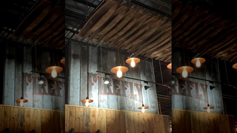 A wall with "Firefly" painted and lights hanging from a ceiling