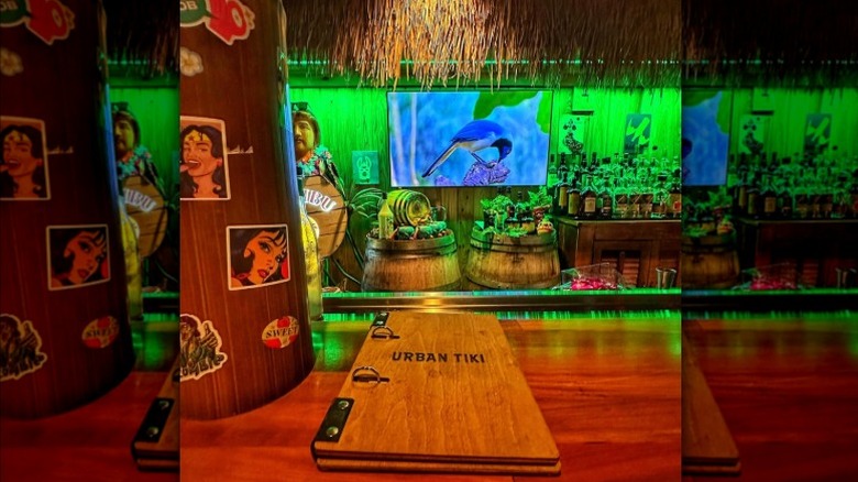 Urban Tiki menu resting on a bar surrounded by themed decor