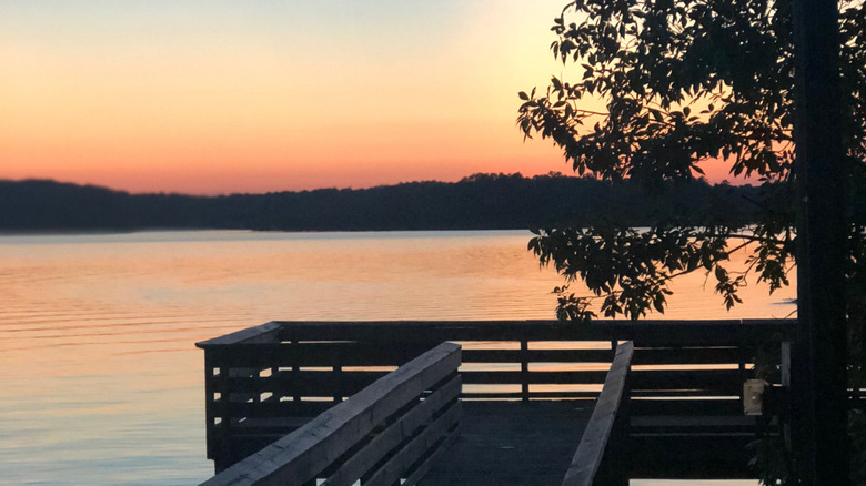 A dock on a lake with sunset