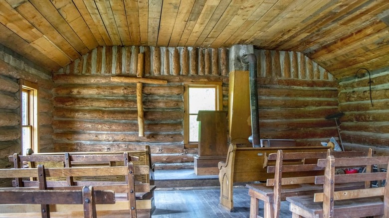 All wooden interior with pews and cross McCahan Memorial Chapel