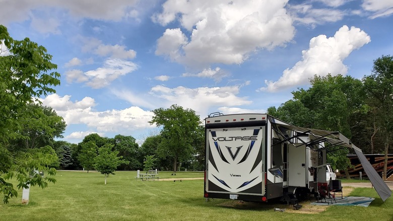 camper set up in green forested area at Fisher Grove State Park