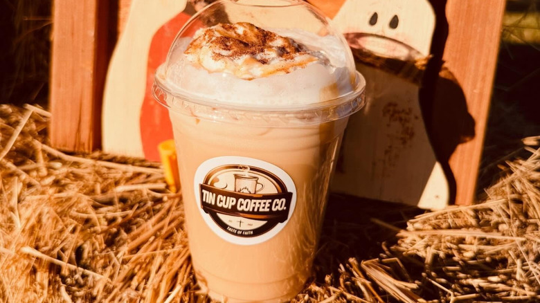 A cold drink from Tin Cup Coffee Co. sitting on hay