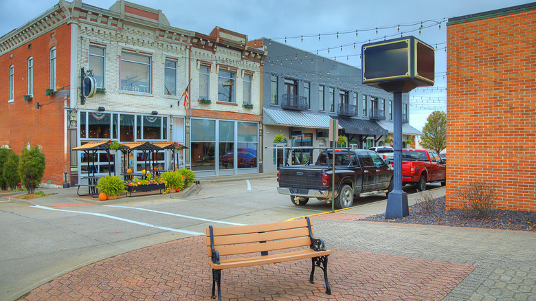A small downtown area with old-fashioned buildings and a wooden bench