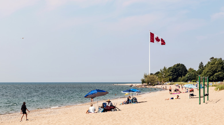 Southampton Beach during the daytime with a Canadian flag and beachgoers