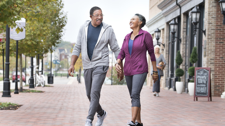 A senior couple enjoys a walk in a small town.