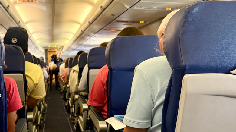The interior cabin of a Southwest Airlines airplane, with passengers seated in cramped-looking seats.
