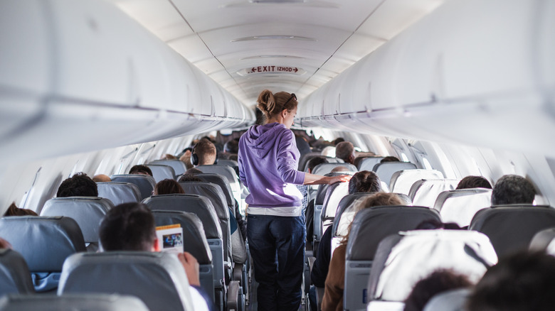 A passenger in the aisle on an airplane