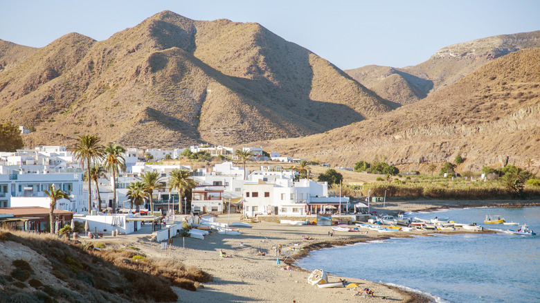 A white-washed town rests by the sea beneath a volcanic mountain range near Spain's Cabo de Gata Natural Park