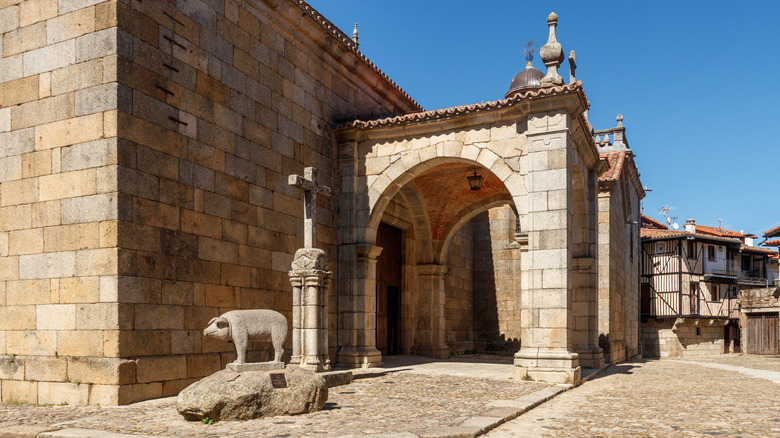 A statue of a pig outside a church in La Alberca