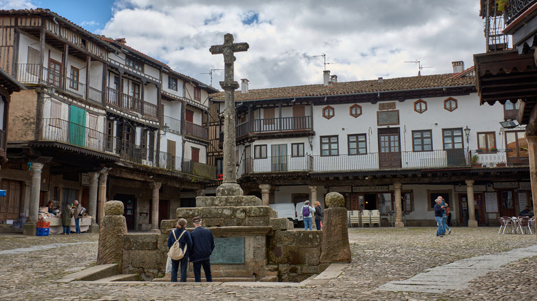 Tourists view a historic town square in La Alberca, Spain
