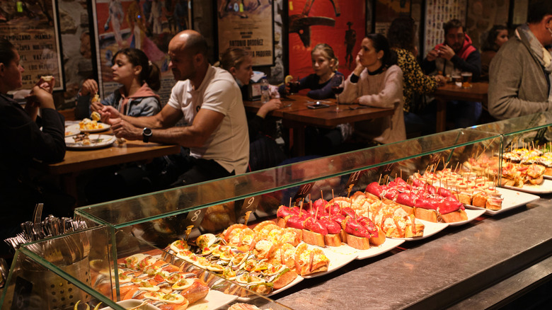 Customers eating at a pinxtos bar in San Sebastian, Spain