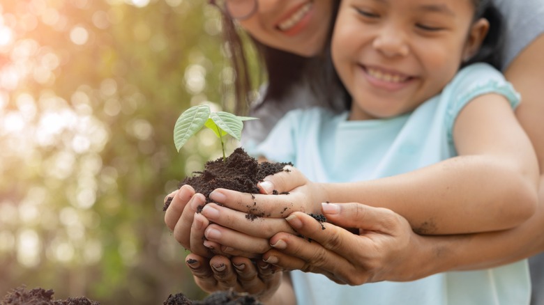 Mom and daughter planting a tree together