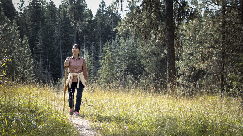 A woman hikes on a wooded trail in Idaho's Panhandle region.