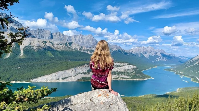 A woman looks over Spray Lakes Reservoir from the Little Lougheed lookout