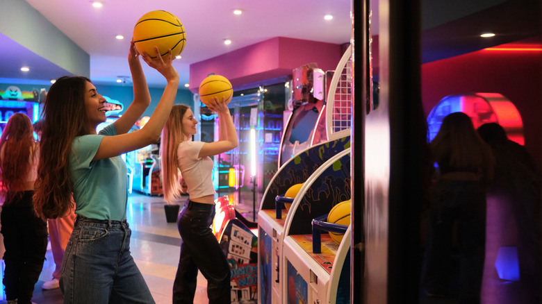 Two girls playing a basketball game in an arcade