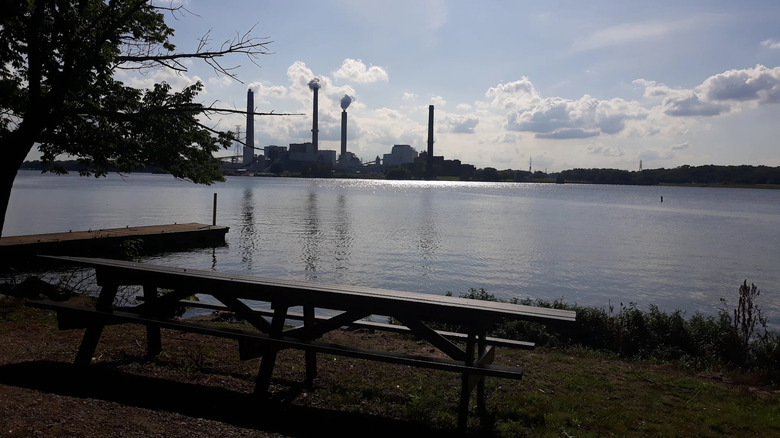 Picnic benches overlooking water and power plant at Tom Madonia Park West