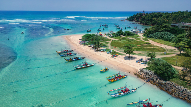Boats moored up against white sands on the south coast of Sri Lanka