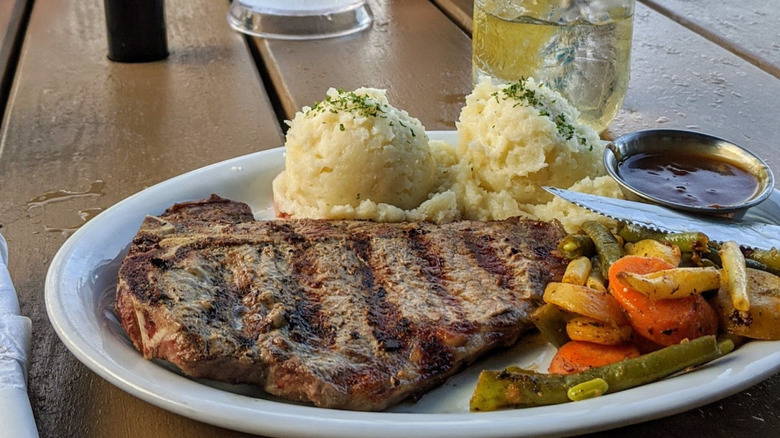 Steak and mash dinner on outdoors terrace at Tiltn' Hilton