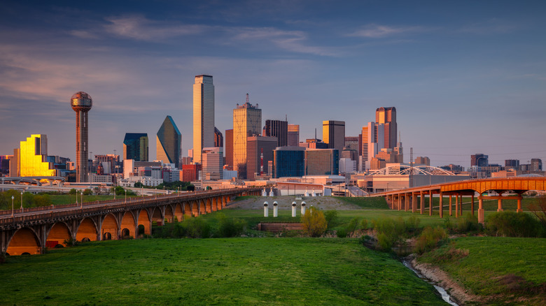 A view of Dallas' cityscape with high-rises and various buildings during sunset