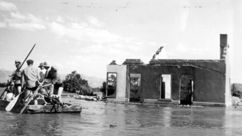 Black and white photo of men rowing away from a ruined building St. Thomas Nevada