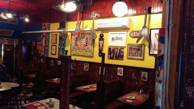 the interior of John's of Bleecker Street, showing booths and art on the wall