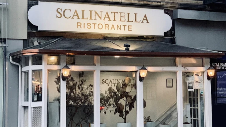The exterior of Scalinatella restaurant, showing signage and greenery