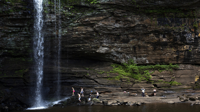 People enjoy the waterfall of Cedar Falls at Petit Jean State Park in Arkansas.