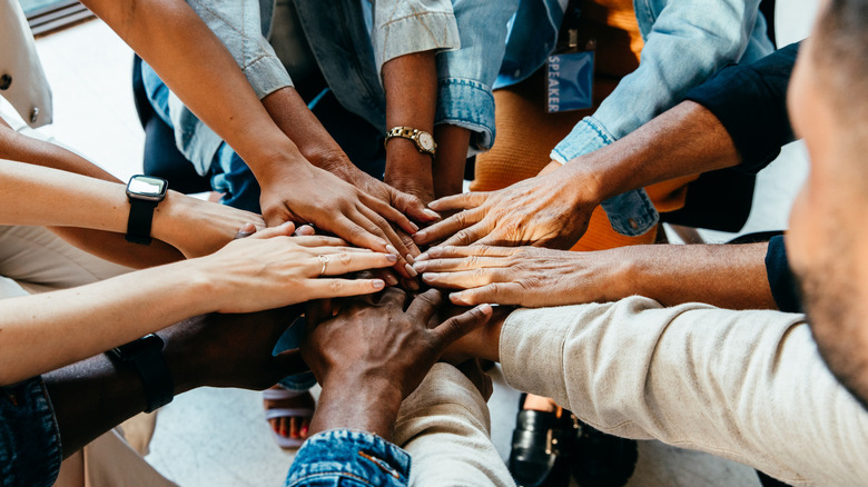 Diverse group of hands joined together