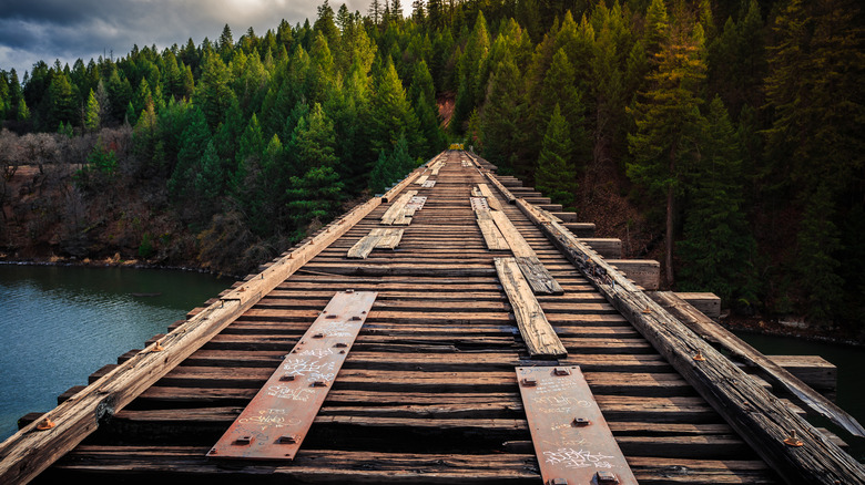 The timber top of the Stand By Me bridge in California with the lake below and trees at one end.