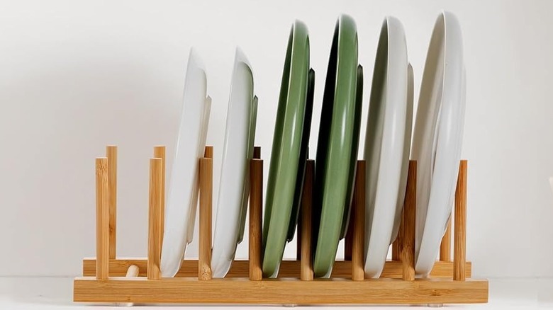 A wooden plate organizer holding dinnerware