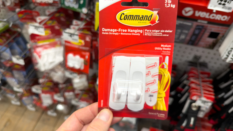 Hand holding Command damage-free hooks