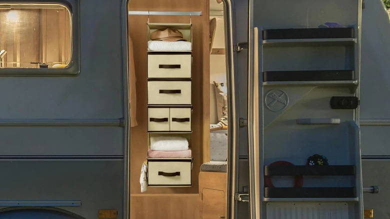 A hanging closet organizer in a tall cabinet inside of a small camper trailer