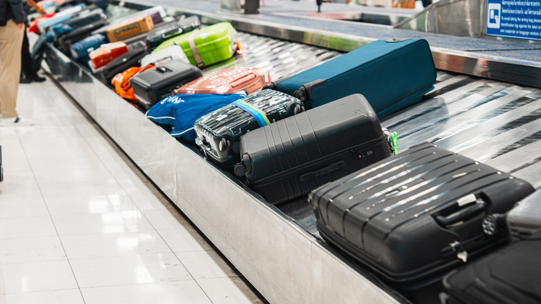 Checked suitcases on baggage conveyor belt