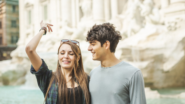 Couple throwing coin in Trevi Fountain