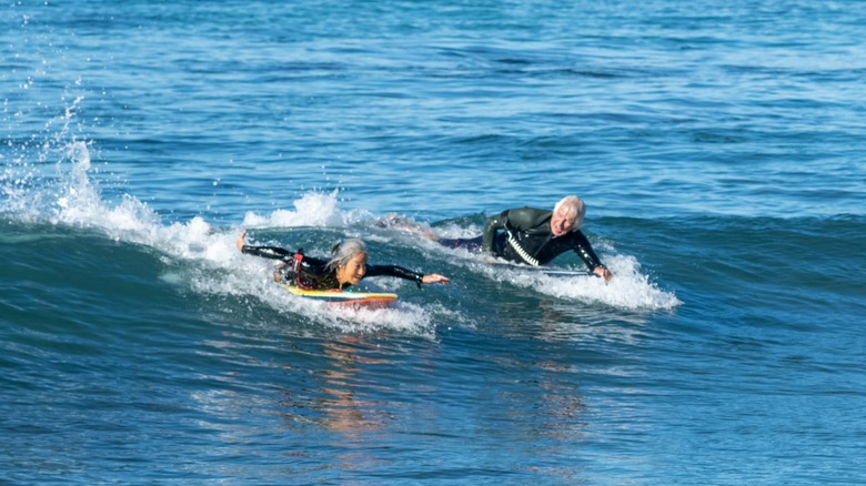 Elderly man and woman surfing in Hawai'i
