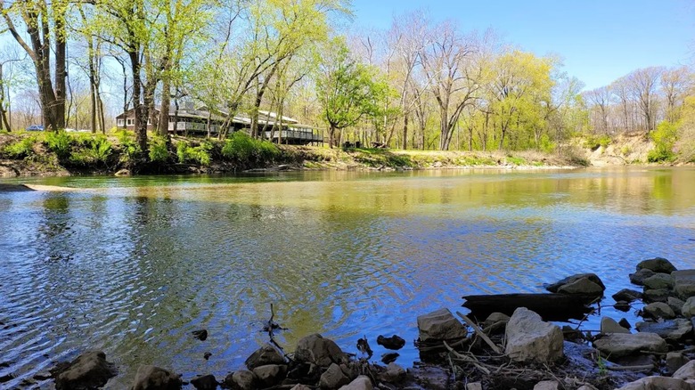 The calm waters of Sugar Creek in Indiana, surrounded by a rocky shoreline and greenery