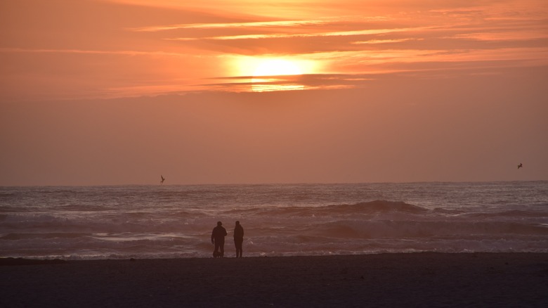 two silhouettes beach sunset