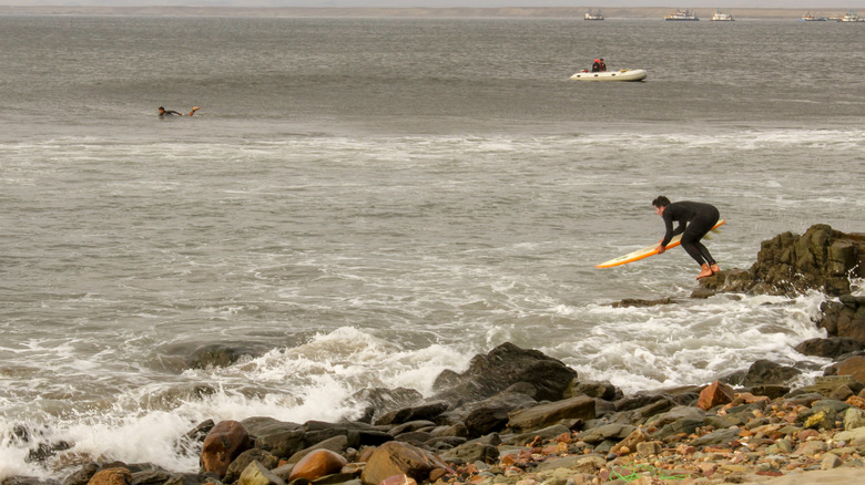 A surfer getting in the water in Chicama