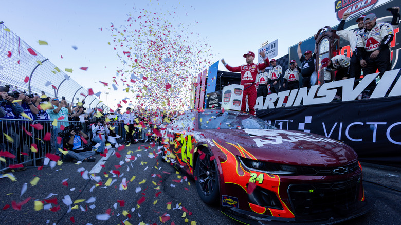 Nascar winner celebrating with fans at a race track