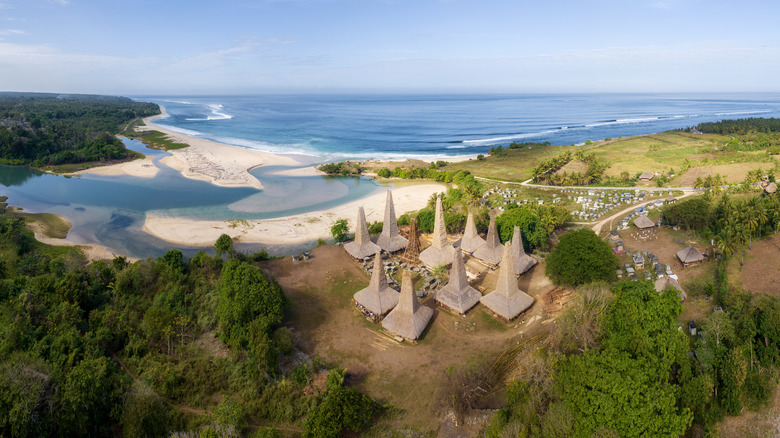 Thatched roof village overlooking lagoon and seahore in Sumba