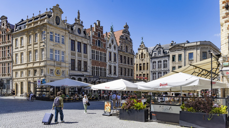 Terrace cafés in a cobbled square surrounded by medieval buildings in Leuven, Belgium