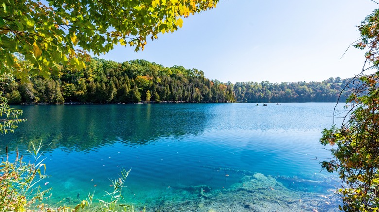 Turquoise lake surrounded by forested hills