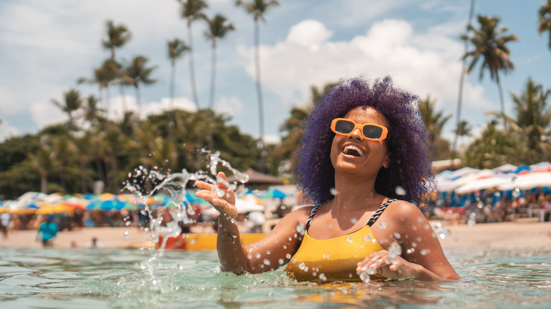 Woman splashing in water at beach