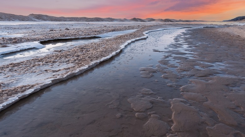 Sunset on winter lake beach
