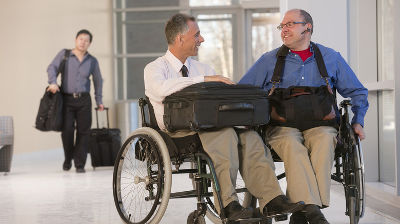 two men in wheelchairs at the airport