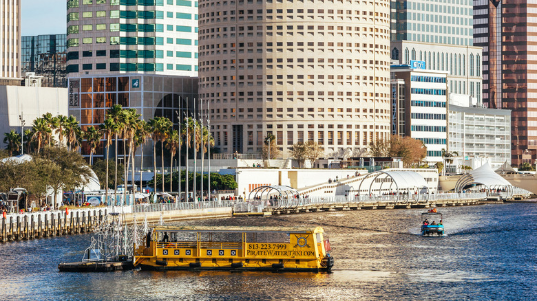 A yellow water taxi collects passengers on the Hillsborough River in Tampa Florida.