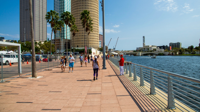 Pedestrians walking down Tampa Riverwalk on a sunny day