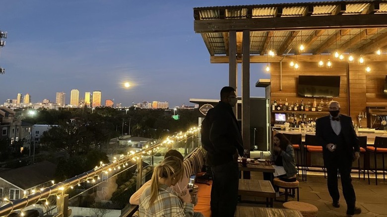 Luna Lounge with patrons enjoying drinks and a view of the Tampa skyline at night